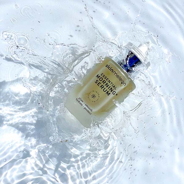 Ein Bild vom essenzielle Morgen Serum, für Ihre Hautpflege von der Marke skinmeleon. Das Serum befindet sich in einer durchsichtigen Glasflasche mit einem Pipettenspender. Der Inhalt ist cremefarben. Die Flasche liegt im Wasser.