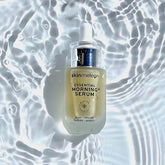 Ein Bild vom essenzielle Morgen Serum, für Ihre Hautpflege von der Marke skinmeleon. Das Serum befindet sich in einer durchsichtigen Glasflasche mit einem Pipettenspender. Der Inhalt ist cremefarben. Die Flasche liegt im Wasser.
