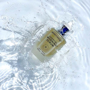 Ein Bild vom essenzielle Morgen Serum, für Ihre Hautpflege von der Marke skinmeleon. Das Serum befindet sich in einer durchsichtigen Glasflasche mit einem Pipettenspender. Der Inhalt ist cremefarben. Die Flasche liegt im Wasser.